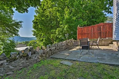 a patio with two chairs and a stone wall at Updated Home with Patio Half Mile to West Point in Highland Falls