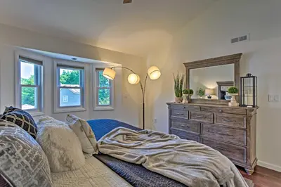 a bedroom with a bed and a dresser with a mirror at Updated Home with Patio Half Mile to West Point in Highland Falls