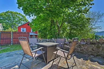 a patio with a table and chairs and a stone wall at Updated Home with Patio Half Mile to West Point in Highland Falls