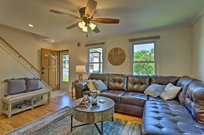 a living room with a leather couch and a ceiling fan at Updated Home with Patio Half Mile to West Point in Highland Falls