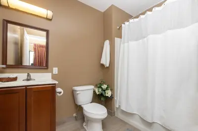 a bathroom with a white toilet and a sink at Brinton Suites in West Chester