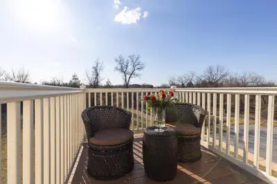 a balcony with two chairs and a vase of flowers at Brinton Suites in West Chester
