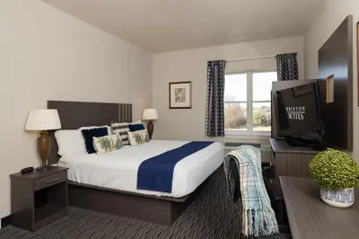 a hotel room with a bed and a television at Brinton Suites in West Chester