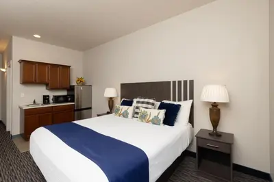 a hotel room with a large bed and a kitchen at Brinton Suites in West Chester