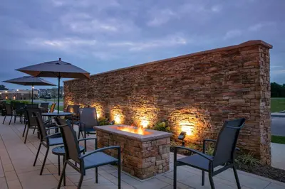 a brick wall with tables and chairs and a fire pit at Fairfield by Marriott Inn & Suites Lebanon Near Expo Center in Lebanon