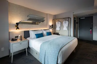 a hotel room with a large bed and a night stand at Pestana CR7 Times Square in New York