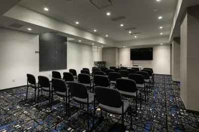 a room with a bunch of chairs and a screen at Pestana CR7 Times Square in New York