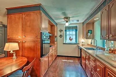 a kitchen with wooden cabinets and a wooden table at Pool and Courtyard Timeless Home in Lansdale in Lansdale