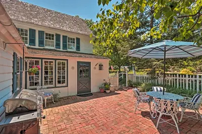 a patio with a table and an umbrella and a grill at Pool and Courtyard Timeless Home in Lansdale in Lansdale