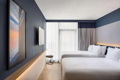 a hotel room with two beds and a large window at Motto by Hilton New York City Chelsea in New York