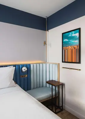 a bedroom with a bed and a table and a picture at Motto by Hilton New York City Chelsea in New York