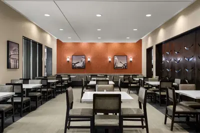 a dining room with tables and chairs at Embassy Suites by Hilton Newark Airport in Elizabeth