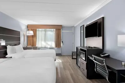 a hotel room with two beds and a desk at Brandywine Valley Inn SureStay Plus by Best Western in Wilmington