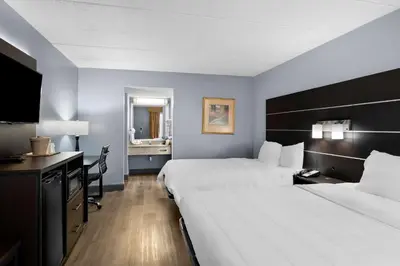 a hotel room with two beds and a desk at Brandywine Valley Inn SureStay Plus by Best Western in Wilmington