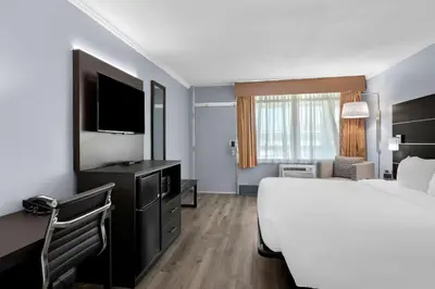a hotel room with a bed and a flat screen tv at Brandywine Valley Inn SureStay Plus by Best Western in Wilmington