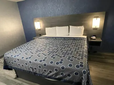 a large bed in a hotel room with two lamps at The Wayne Inn in Wayne