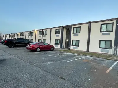 a red car parked in a parking lot in front of a building at The Wayne Inn in Wayne