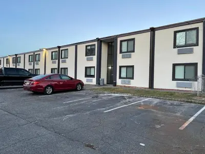a red car parked in a parking lot in front of a building at The Wayne Inn in Wayne