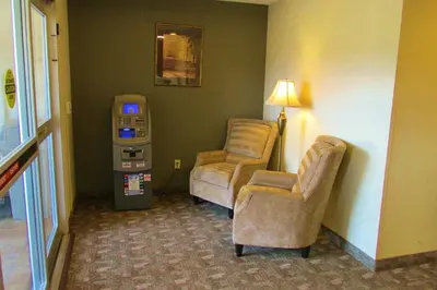 a hotel room with two chairs and a parking meter at Crystal Springs Inn and Suites in Towanda