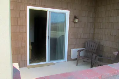 a porch with a chair and a sliding glass door at Crystal Springs Inn and Suites in Towanda