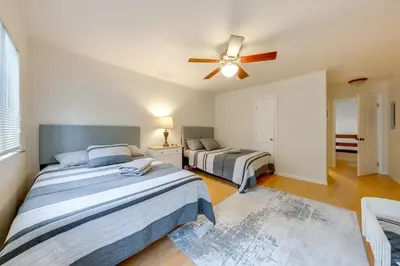 two beds in a bedroom with a ceiling fan at Near Skiing and Lakes Contemporary Poconos Townhome in Lake Harmony