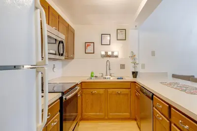 a kitchen with wooden cabinets and a sink at Near Skiing and Lakes Contemporary Poconos Townhome in Lake Harmony