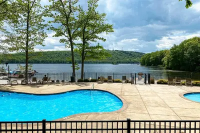 a swimming pool with a view of a lake at Near Skiing and Lakes Contemporary Poconos Townhome in Lake Harmony