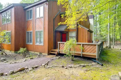 a large wooden house with a large front porch at Near Skiing and Lakes Contemporary Poconos Townhome in Lake Harmony