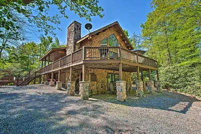 a log home with a wrap around deck at Fire Pit and Hot Tub Poconos Family Cabin! in Long Pond