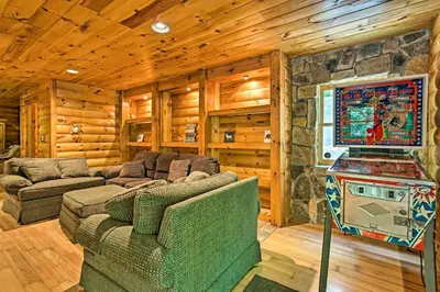 a living room with a couch and a flat screen tv at Fire Pit and Hot Tub Poconos Family Cabin! in Long Pond