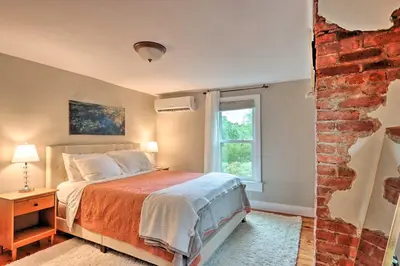 a bedroom with a bed and a brick wall at Charming Abode with Patio - Walk to Town and River! in Stockton