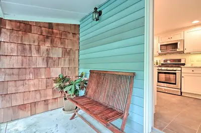 a wooden bench sitting on a porch with a kitchen at Charming Abode with Patio - Walk to Town and River! in Stockton