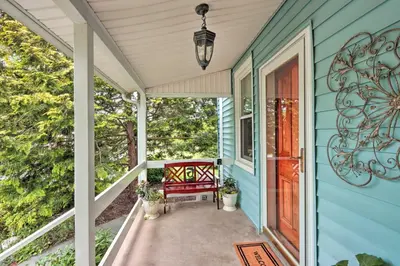 a porch with a red bench on a blue house at Charming Abode with Patio - Walk to Town and River! in Stockton