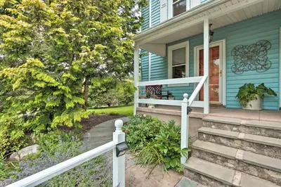 a blue house with stairs leading to the front door at Charming Abode with Patio - Walk to Town and River! in Stockton