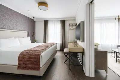 a hotel room with a bed and a television at The Wallace Hotel in New York