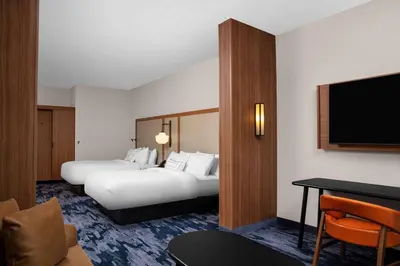 a hotel room with two beds and a flat screen tv at Fairfield by Marriott Inn & Suites Lewisburg in Lewisburg