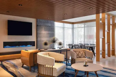 a lobby with chairs and a flat screen tv at Fairfield by Marriott Inn & Suites Lewisburg in Lewisburg