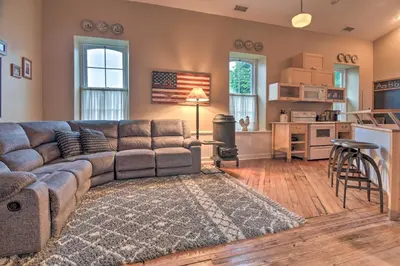 a living room with a couch and a kitchen at Private Hot Tub at Cozy Wrightsville Cottage! in Wrightsville