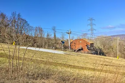 a field with a house on the side of a road at Mountain Creek Condo with Grill Walk to Lifts! in Vernon