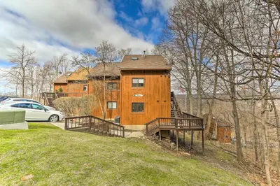 a large wooden building on a hill with a car at Mountain Creek Condo with Grill Walk to Lifts! in Vernon