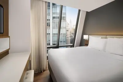 a hotel room with a large bed and a large window at Best Western Premier Empire State Hotel in New York