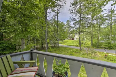 a balcony with a table and a chair and a street at Deck and Pool Access Welcoming Poconos Retreat in Tobyhanna