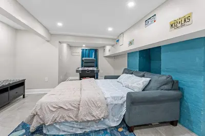 a bedroom with a bed and a blue wall at 15min to Lincoln Ecuador vs Ivory Coast, Sleeps 12 in East Lansdowne