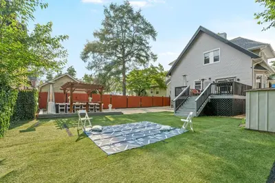 a backyard with a table and chairs on the grass at 15min to Lincoln Ecuador vs Ivory Coast, Sleeps 12 in East Lansdowne