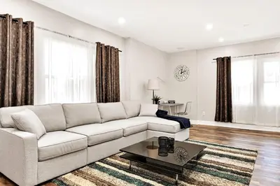 a white living room with a couch and a table at 15min to Lincoln Ecuador vs Ivory Coast, Sleeps 12 in East Lansdowne