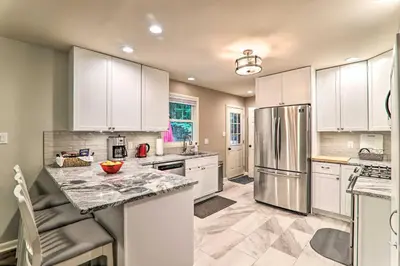 a kitchen with white cabinets and a stainless steel refrigerator at Sunroom, Fire Pit and Sauna Lake Locust Village Gem in Pocono Lake