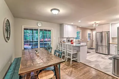 a kitchen with a wooden table in the middle at Sunroom, Fire Pit and Sauna Lake Locust Village Gem in Pocono Lake