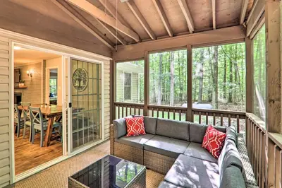 a screened in porch with a couch and a table at Sunroom, Fire Pit and Sauna Lake Locust Village Gem in Pocono Lake