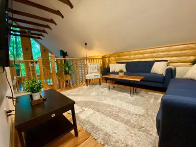 a living room with a blue couch and a table at Lakeview Cabin in The Hideout in Lake Ariel