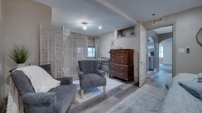 a bedroom with a bed and two chairs and a dresser at The Suite in a historic carriage house in Kennett Square